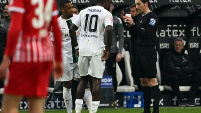 Nach der Schwalbe von Marcus Thuram (M.) im Spiel gegen Freiburg wird über härtere Strafen für solche Szenen diskutiert. (Foto: Federico Gambarini/dpa)