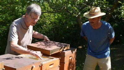 Ulrich Bauer vom Imkerverein Höchstadt/Aisch und Umgebung e.V. zeigt Wildlebensraumberater Hermann Willfarth vom AELF Fürth-Uffenheim wie die Bienen im Bienenstock nach der Honigernte gefüttert werden. (Foto: Anja Herrmann)