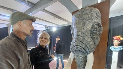 Laura Bräuninger mit einem Vernissagengast: Der von ihr mit der Motorsäge gestaltete Elefantenkopf ist mittlerweile schon eine Art Wahrzeichen der Künstlerin.  (Foto: Sandra Buchwald)