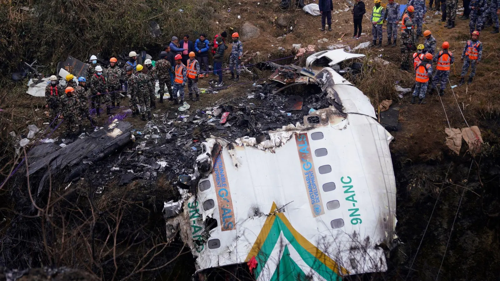 Rettungskräfte an der Absturzstelle. (Foto: Yunish Gurung/AP/dpa)