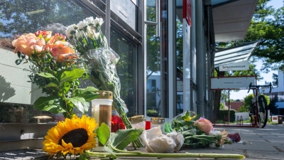 Menschen legten nach dem tödlichen Angriff Blumen und Kerzen vor der Filiale ab. (Foto: Armin Weigel/dpa)