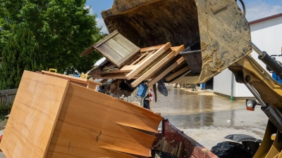 Im Bauhof wird mit einem Radlader der durch Hochwasser entstandene Sperrmüll in einen Container gekippt. (Foto: Stefan Puchner/dpa)