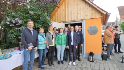 Die Landfrauen bekamen bei der Einweihung viel Lob. Das Foto zeigt sie mit Pfarrer Johannes Raithel (links) und Bürgermeister Johannes Schneider (vor der Tür). Auch der Posaunenchor spielte auf. (Foto: Karl-Heinz Gisbertz)