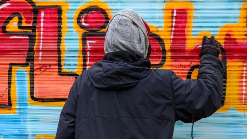 Graffiti in Ansbach: In einer Unterführung an der Nürnberger Straße hat ein Unbekannter am Montagabend einen großen Schriftzug gesprüht – und ist auf einem blauen Motorroller geflüchtet. (Symbolbild: Patrick Pleul/dpa)