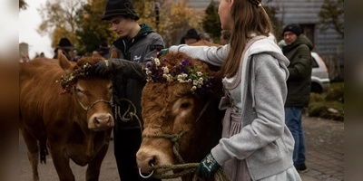 Sitzt der Kopfschmuck noch? Während des Almabtriebs richten die Frauen und Männer die Blütenkrönchen.  (Foto: Evi Lemberger)