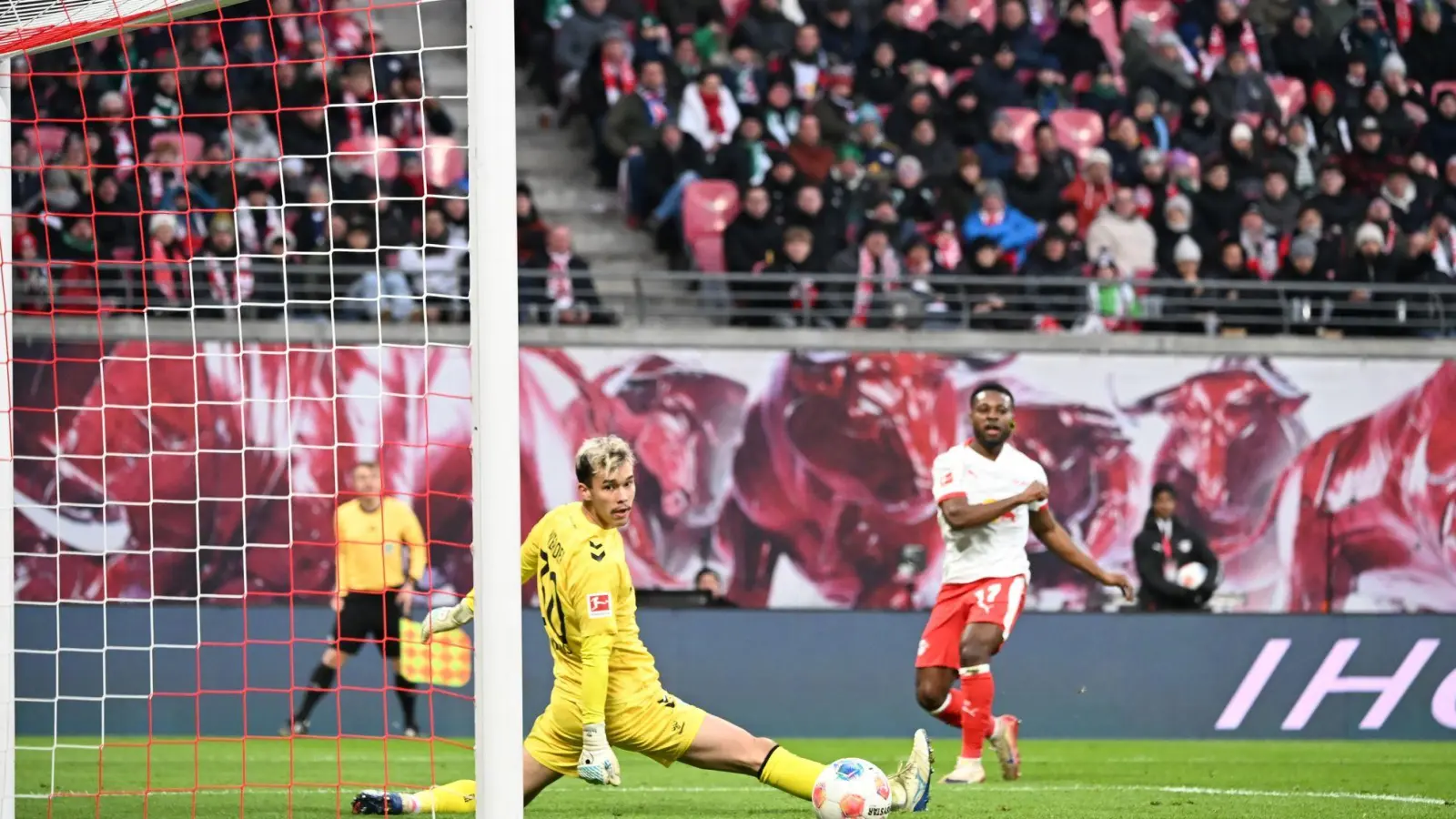 Bremens Torwart Mio Backhaus (l, Werder Bremen) und Ridle Baku (RB&nbsp;Leipzig) schauen dem Ball hinterher. Backhaus verhinderte mit seinen Paraden einen frühen Rückstand der Gäste in Leipzig. (Foto: Jennifer Brückner/dpa)