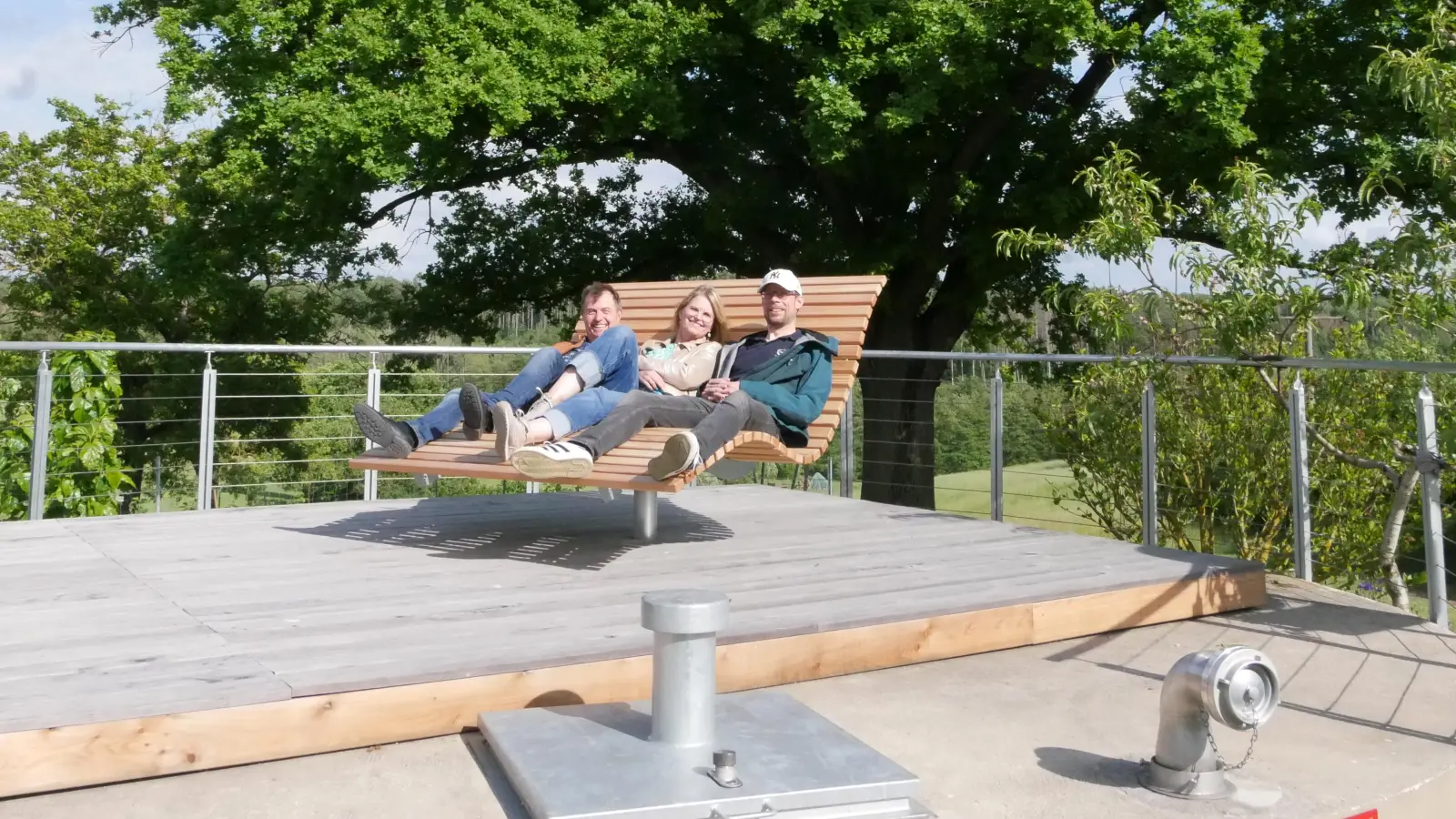 Zwei mit einem Betondeckel verschlossene ehemalige Güllegruben dienen als Wasserreservoir. Bei Arbeitseinsätzen wurde der Platz mit guter Aussicht nun zum Sonnendeck umfunktioniert, wie neben Georg Helm und Frauke Plog-Bell auch Thorsten Graf (v.l.) demonstriert. (Foto: Ulli Ganter)