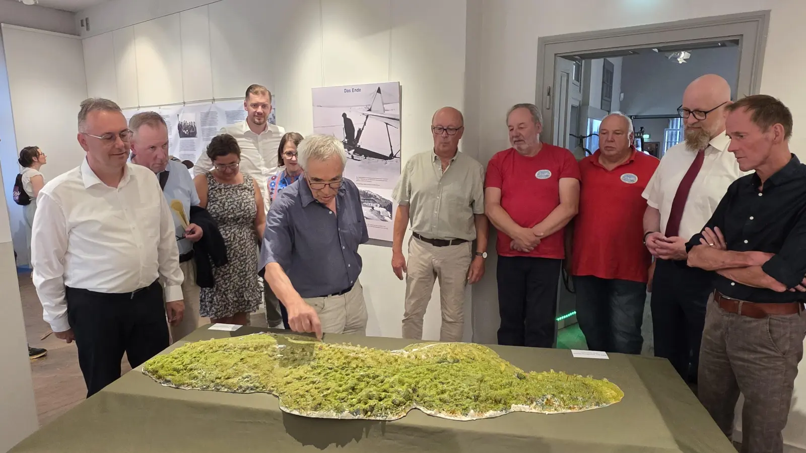 Ein Modell des Hesselbergs veranschaulicht die Nutzung der Berghänge in den Anfangsjahren der Segelfliegerei in Bayern. Bei der Ausstellungseröffnung erläuterte der Historiker und Autor Harald Fischer den Ehrengästen und Vertretern des Luftsportvereins und des Modellflug-Clubs die damalige Situation.  (Foto: Markus Weinzierl)