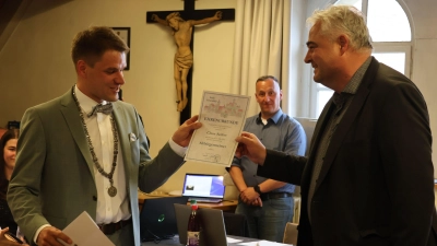 Scheinfelds neuer Bürgermeister Theodor Schell (links) überreicht seinem Amtsvorgänger Claus Seifert (rechts) die Ernennungsurkunde zum Altbürgermeister. Im Hintergrund sieht der designierte neue Geschäftsleiter Sebastian Thiehove zu. (Foto: Andreas Reum)