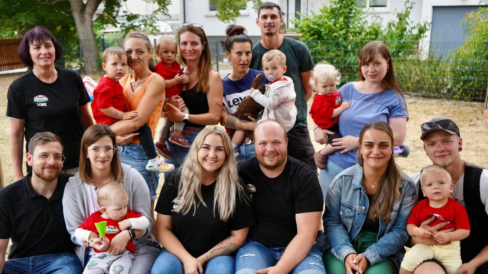 Alina Hirsch und René Schäfer (vorne sitzend in der Mitte, schwarze T-Shirts) haben in Unternesselbach eine Großtagespflege eröffnet. Am Tag der Offenen Tür gesellten sich einige Eltern mit ihren „Dorfzwergen“ mit aufs Gruppenbild. (Foto: Nadine Renner)