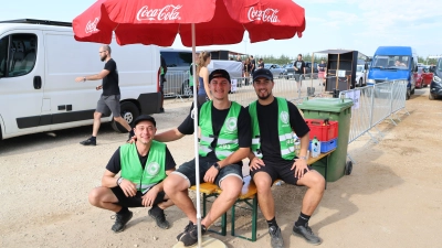 Ferhat, Andreas und Luca (von links) sind an der Einlass-Schleuse dafür zuständig, dass das Einchecken der Fans möglichst reibungslos läuft. Am Dienstag Vormittag ist die Lage entspannt. (Foto: Martina Haas)