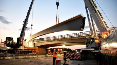 Zwei Schwerlastkräne hieven das erste große Brückenteil hoch. (Foto: Erich Kraus)