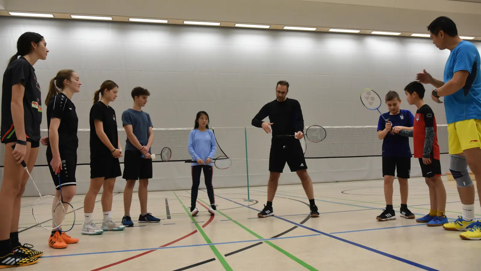 Abteilungsleiter Faruk Beskardesler erklärt die richtige Haltung des Schlägers. Sie ist so, als ob man jemandem die Hand gibt. Rechts im Bild ist Trainer Mingjun Zhou. (Foto: Anita Dlugoß)