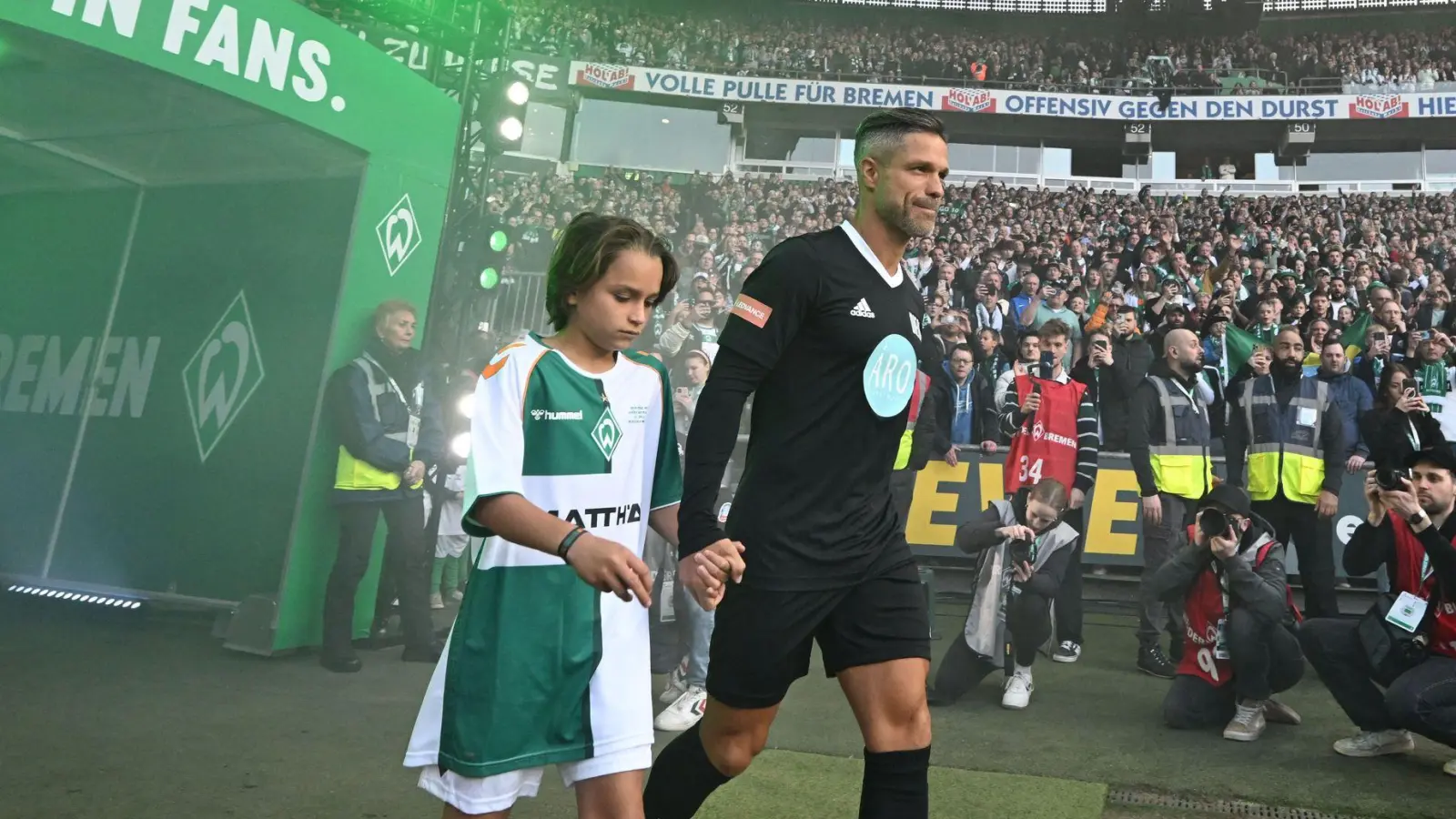 Gemeinsam mit seinem Sohn Matteo betritt Diego  bei seinem Abschiedsspiel das Bremer Weserstadion. (Foto: Carmen Jaspersen/dpa)