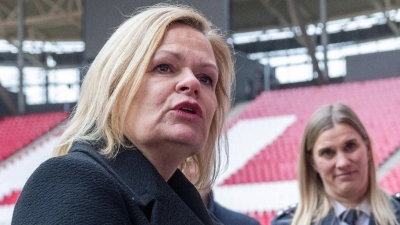 Nancy Faeser (SPD, l), Bundesinnenministerin, unterhält sich in der Leipziger Arena mit Vertretern der Polizei. (Foto: Hendrik Schmidt/dpa)