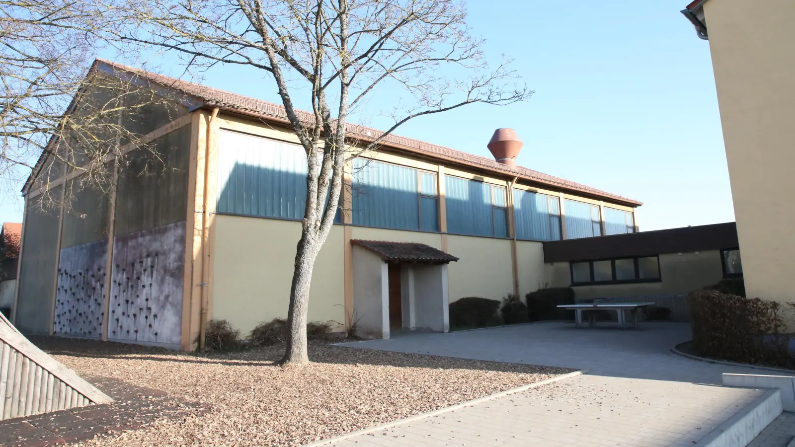Die Mehrzweckhalle in Flachslanden soll generalsaniert und nach Süden hin erweitert werden. Dadurch wird der Pausenhof für die Grundschule Flachslanden ein weniger kleiner.  (Foto: Alexander Biernoth)
