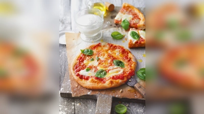 Die Pizza Margherita mit Basilikum, Mozzarella und Parmesan kommt nicht ohne Tomatensauce. Dafür am besten stückige Tomaten aus der Dose nehmen und mit Salz, Pfeffer, einer Prise Zucker und bei Bedarf mit etwas Oregano und frischem Knoblauch abschmecken. (Foto: Kramp Gölling/Gräfe und Unzer/dpa-tmn)