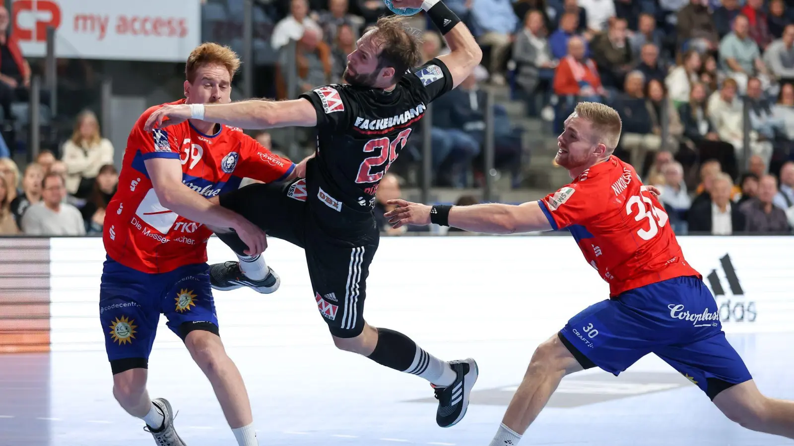 Nico Büdel (M) vom HC Erlangen kämpft sich an Lukas Stutzke (l) und Tom Kare Nikolaisen vom Bergischen HC vorbei. (Foto: Daniel Karmann/dpa/Archivbild)