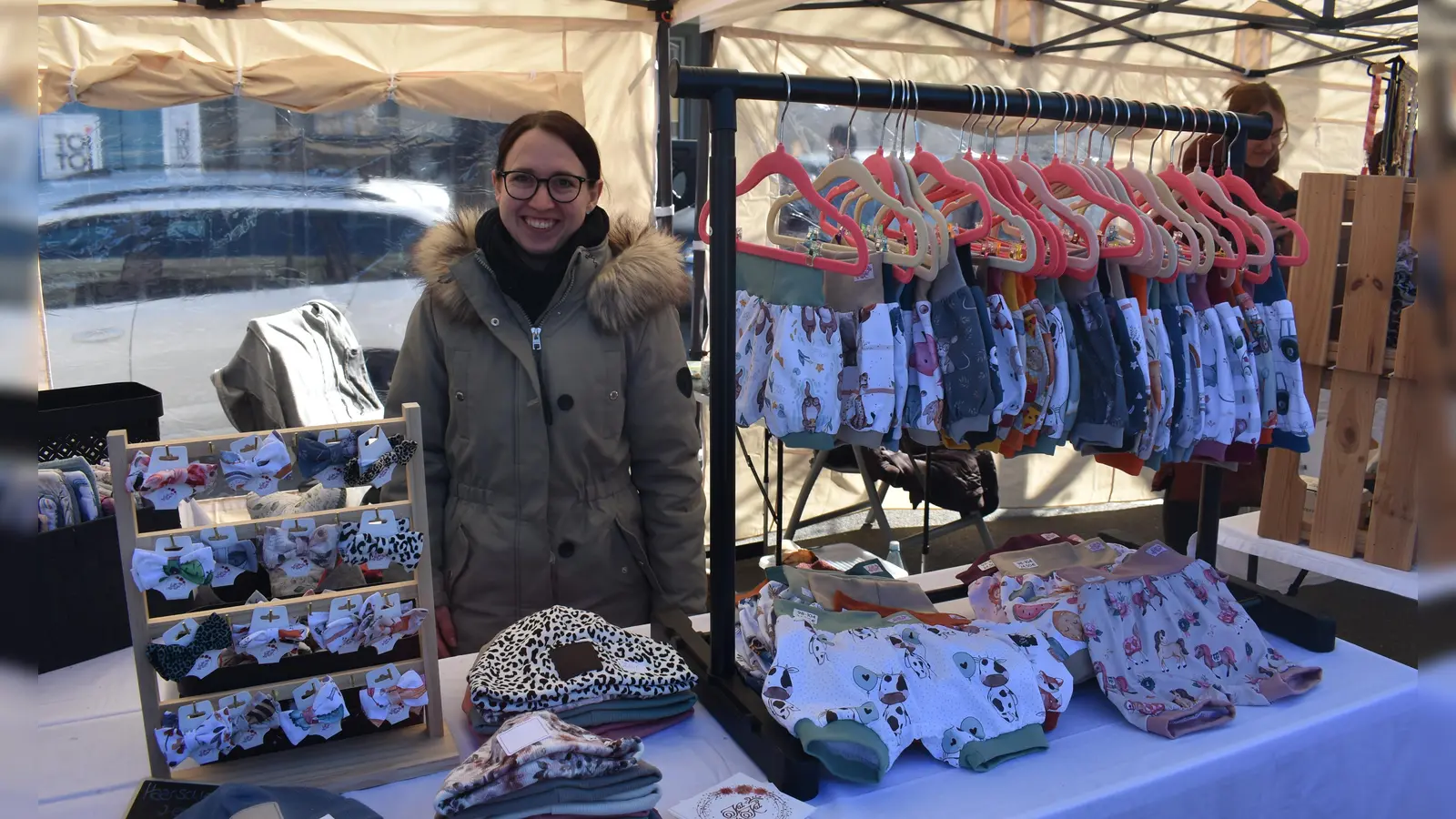 Yvonne Motzek verkauft von allem auf Märkten wie hier auf dem Matthiasmarkt in Neustadt die von ihr genähte Kinderbekleidung. Gut gehen auch Partnermützen für Geschwister oder gleich die ganze Familie. (Foto: Ute Niephaus)