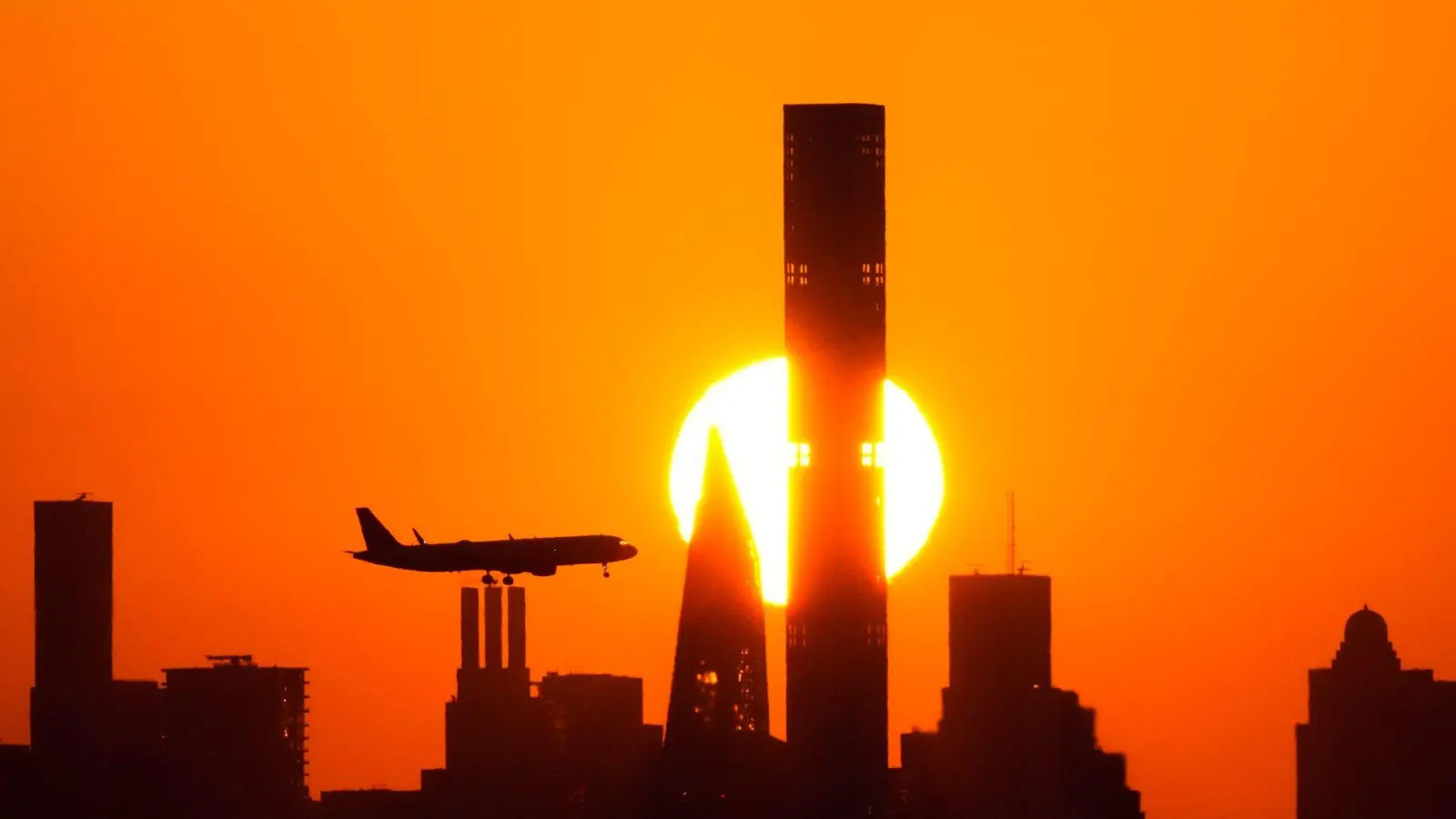 Flugzeug vor der Skyline: Für einige Reisende platzt der Traum vom US-Urlaub. (Archivbild) (Foto: Frank Franklin II/AP)