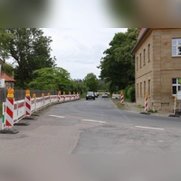 Die Kurve bei der alten Schlossgaststätte (rechts) gilt als Nadelöhr für den Verkehr, vor allem während der Schulbuszeiten. In diesem Bereich wird mit der Sanierung der Staatsstraße in Klosterdorf auch eine Ampel errichtet. Die Barken grenzen aktuell einen Fußgängerbereich ab, in dem es künftig einen regulären Gehweg geben soll. (Foto: Andreas Reum)