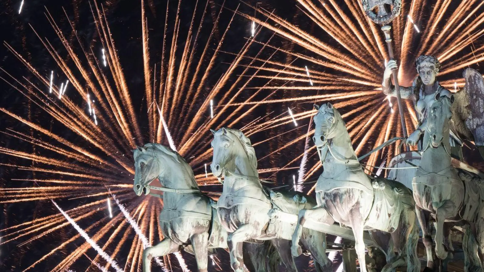 Das Feuerwerk zum Jahreswechsel steigt hinter dem Brandenburger Tor auf. (Foto: Sebastian Christoph Gollnow/dpa)