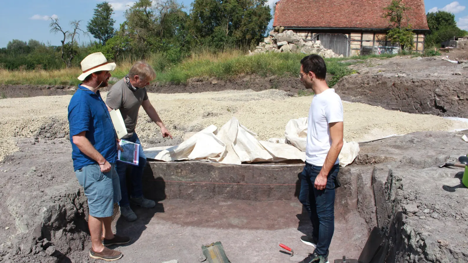 Archäologe Bernd Kriens zeigt Manuel Döhler und Dr. Christoph Lobinger Verfärbungen der Erdschichten. (Foto: Irmeli Pohl)