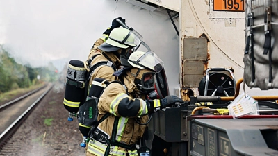 Unter Atemschutz versuchten Feuerwehrleute, den Gasaustritt am Waggon zu stoppen. (Foto: Ralf Hettler/dpa)