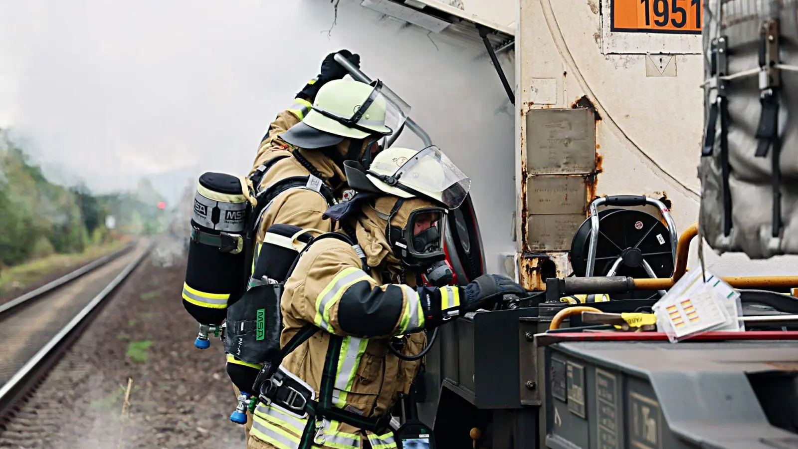 Unter Atemschutz versuchten Feuerwehrleute, den Gasaustritt am Waggon zu stoppen. (Foto: Ralf Hettler/dpa)