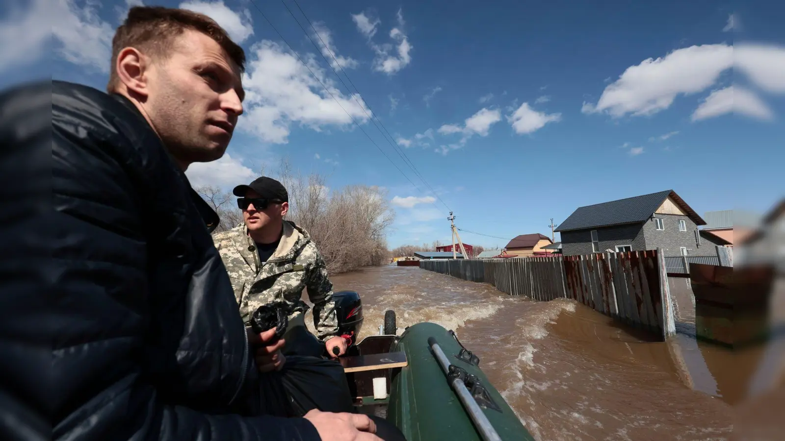 Anwohner fahren in ihrem Schlauchboot, um bei der Evakuierung von Menschen in Orenburg zu helfen. (Foto: Uncredited/AP/dpa)