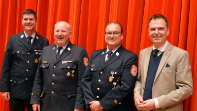 Landrat Dr. Christian von Dobschütz (rechts) ehrte Matthias Helm, Alfred Tilz und Karl-Heinz Köberer (von links) für ihre Leistungen im Feuerwehrdienst. (Foto: Johannes Zimmermann)