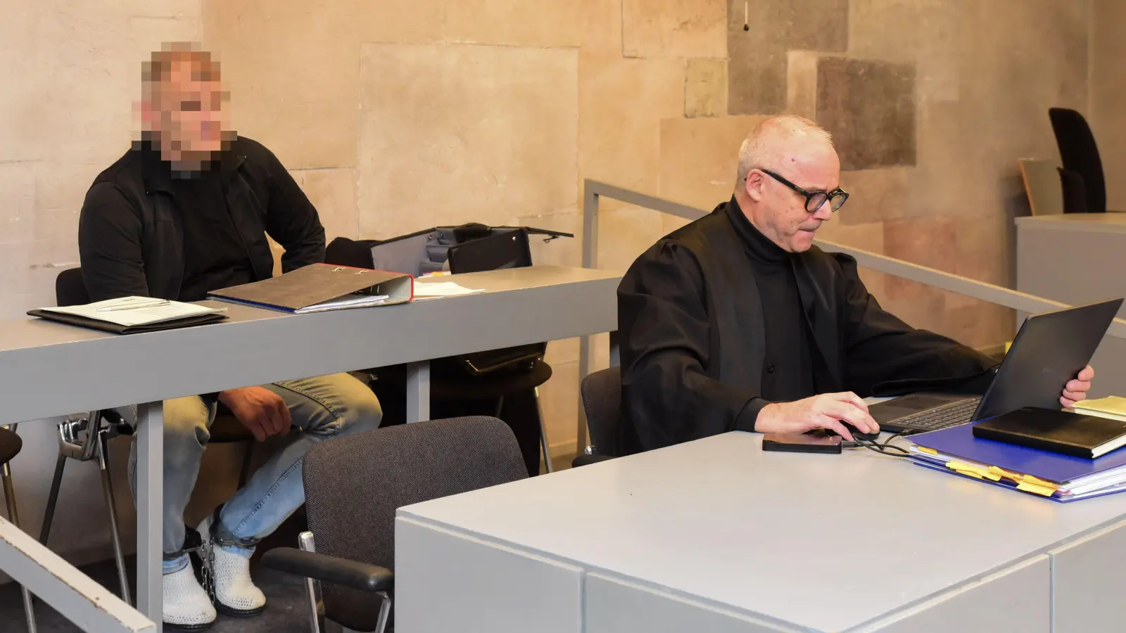 Der Angeklagte (hinten) schweigt zu den Vorwürfen. Sein Verteidiger Dr. Justen Detlef (rechts vorne) erklärte aber in seinem Namen, dass er die Vorwürfe bestreitet. (Foto: Irmeli Pohl)