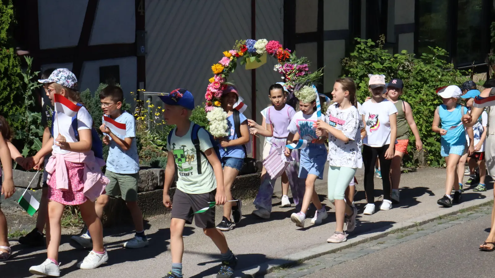 Mit Blumen und Fahnen zogen die Kinder den Kronenwirtsberg hoch. (Foto: Antonia Müller)