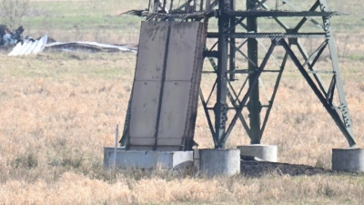 Der verbrannte Strommast auf einem Feld unweit der Tesla-Fabrik in Grünheide. (Foto: Sebastian Gollnow/dpa)