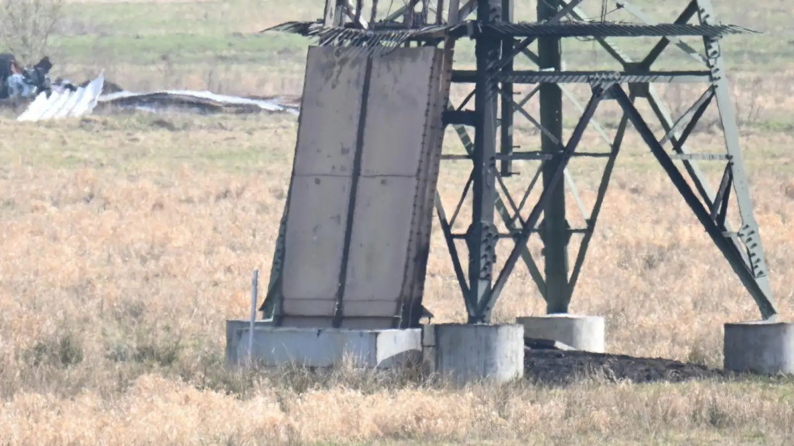 Der verbrannte Strommast auf einem Feld unweit der Tesla-Fabrik in Grünheide. (Foto: Sebastian Gollnow/dpa)