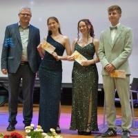 Studiendirektor Norbert Zips mit den drei Besten des Jahrgangs, Emmy Pfab, Nele Reumschüssel und Ben Dreßel (von links). (Foto: Christoph Lange)