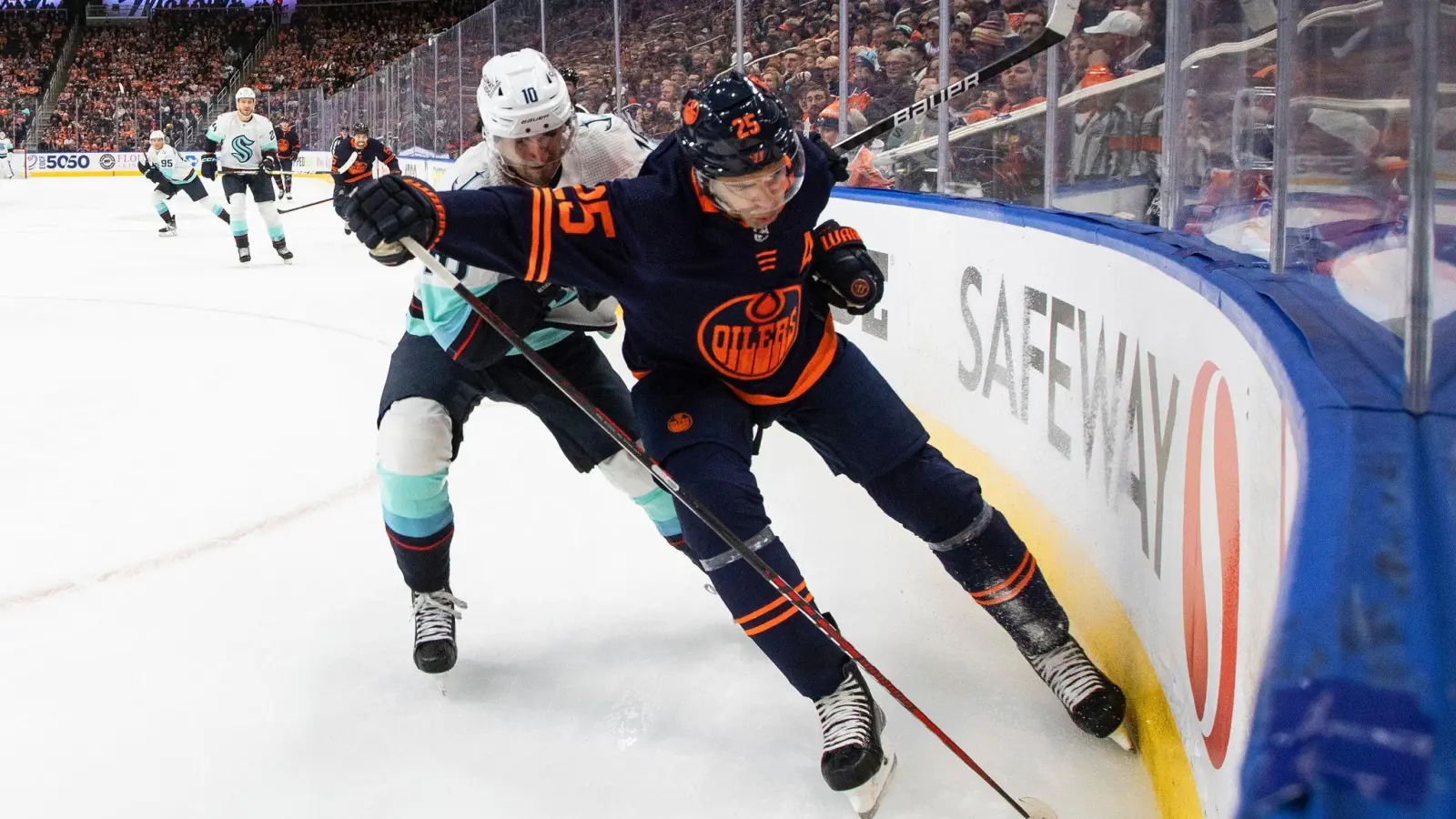 Matty Beniers (10) von den Seattle Kraken und Darnell Nurse (25) von den Edmonton Oilers kämpfen um den Puck. (Foto: Jason Franson/The Canadian Press/AP/dpa)