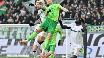 Wolfsburgs Patrick Wimmer (M) und Leverkusens Robert Andrich (l) im Kopfballduell.  (Foto: Swen Pförtner/dpa)