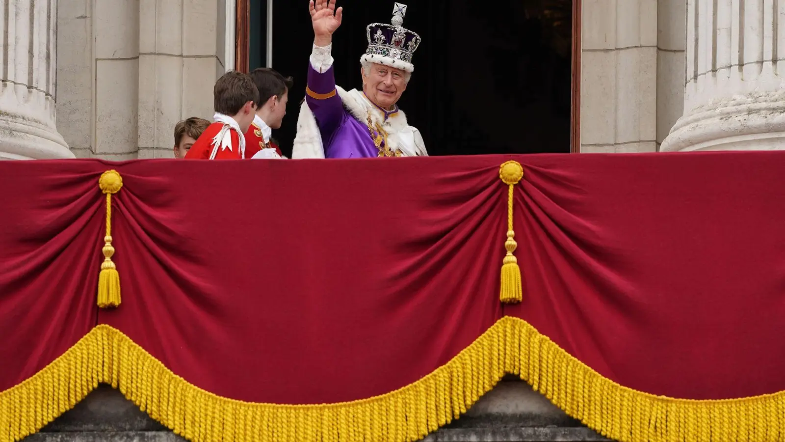 König Charles III. winkt nach der Krönungszeremonie vom Balkon des Buckingham-Palastes. (Foto: Stefan Rousseau/PA Wire/dpa)