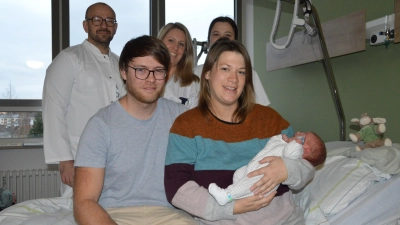 Selig schläft Paul, das Neujahrsbaby im Landkreis, in den Armen seiner Mutter Jana Schmidt. Neben ihr sitzt Papa Simon Windl, dahinter stehen (von links) Chefarzt Dr. Norbert Maczo und die Schwestern Rebecca Cousin und Sarah Gidion.  (Foto: Patrick Lauer)
