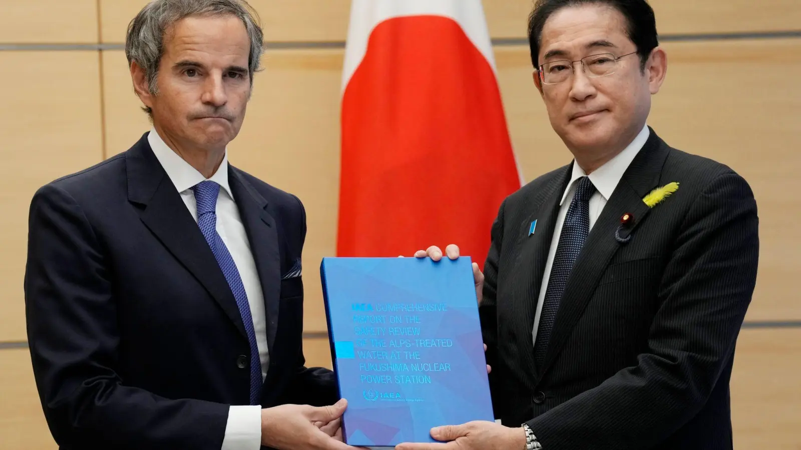 IAEA-Generaldirektor Rafael Grossi (l) überreicht Japans Ministerpräsident Fumio Kishida den Abschlussbericht der Internationalen Atomenergiebehörde. (Foto: Eugene Hoshiko/Pool AP/AP/dpa)