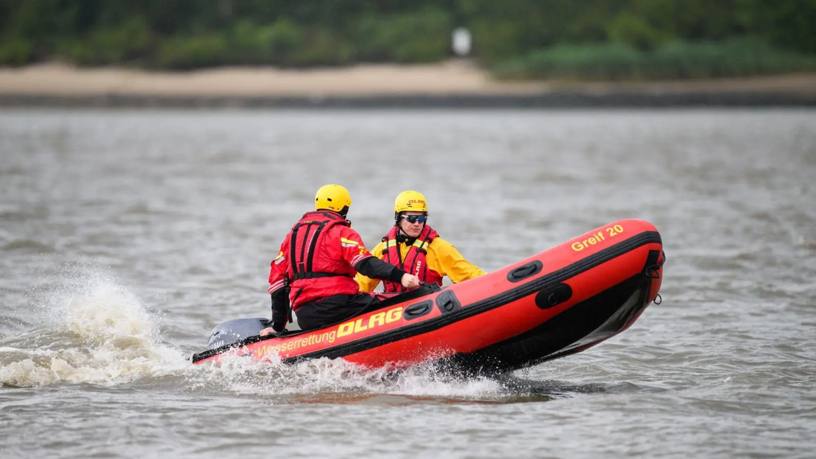 Zwei DLRG-Retter mit einem Schlauchboot auf der Elbe. (Foto: Daniel Reinhardt/dpa)