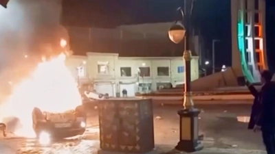 Autos und auch Gebäude sollen bei den Protesten im Iran in Flammen aufgegangen sein. (Foto: Uncredited/Iran state TV/AP/dpa)
