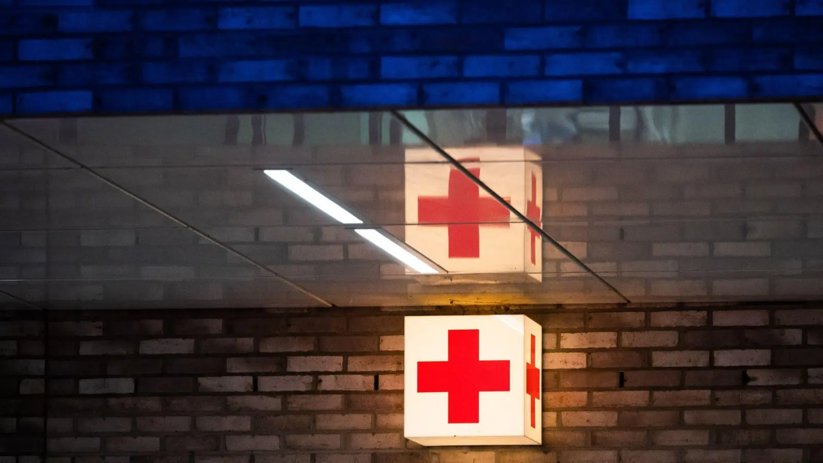 Ein Leuchtkasten mit einem roten&nbsp;Kreuz hängt vor der Notaufnahme eines Krankenhauses. (Foto: Julian Stratenschulte/dpa/Symbolbild)