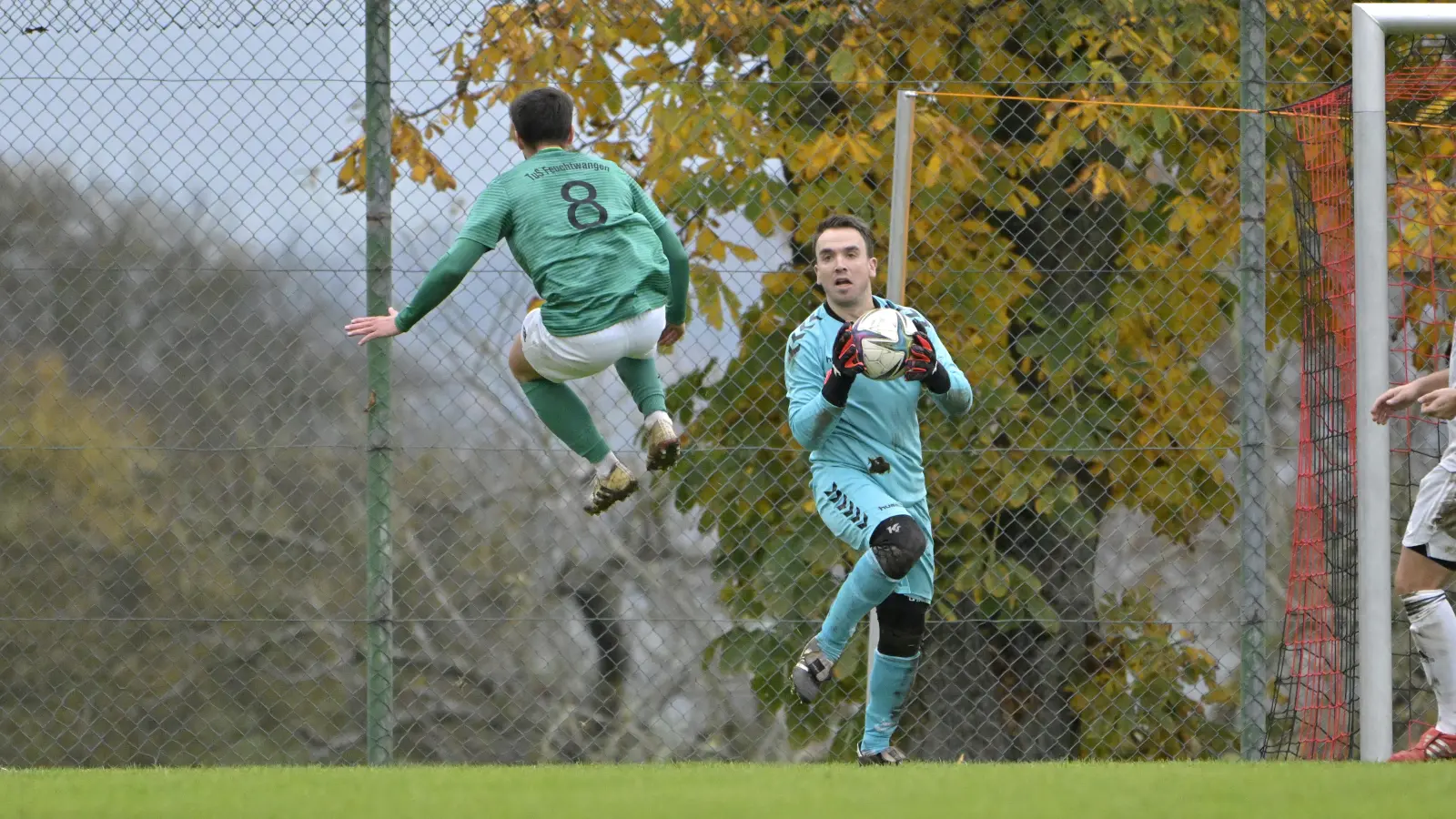 „Nanu, was kommt denn da für ein Flugobjekt auf mich zu?”, mag sich Aufkirchens Torwart Marco Probst hier fragen. Es ist der Feuchtwanger Marcus Roid, der im Bezirksligaspiel mit seinem TuS nach einer 1:6-Niederlage auf dem Boden der Tatsache landete. (Foto: Martin Rügner)