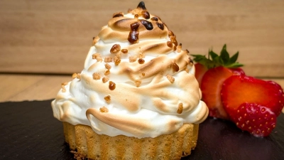 Sieht wie ein Törtchen mit Sahne aus, doch es hat einen eiskalten Kern: Der Eischnee, der hier beim Grillen zum Baiser wird, verhindert als schützende Hülle, dass das Eis im Inneren schmilzt. (Foto: Volker Elm/dpa-tmn)