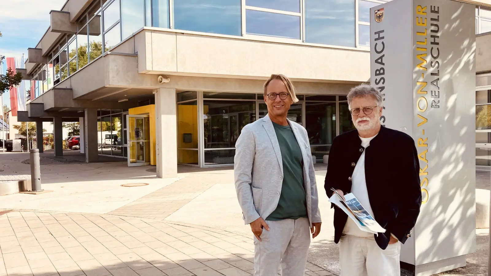 Schulleiter Alexander Müller (links) und Stadtheimatpfleger Hans-Gustaf Weltzer sind begeistert von der Architektur der Oskar-von-Miller-Realschule. (Foto: Corinna Müller)