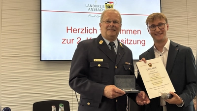 Der scheidende Kreisbrandrat Thomas Müller (links) erhielt die Auszeichnung aus der Hand von Landrat Marco Meier (rechts). (Foto: Annika Köchling (a.koechling@flz.de))