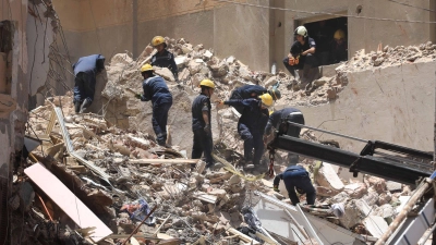 Mitglieder des ägyptischen Zivilschutzes bei den Überresten des eingestürzten 13-stöckigen Wohngebäudes in Alexandria. (Foto: Stringer/dpa)