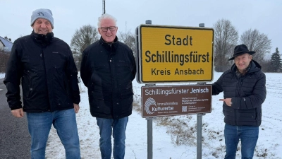 Auf die Jenisch-Sprachinsel Schillingsfürst weisen nun auch braune Hinweistafeln unter den gelben Ortsschildern hin. Das Foto zeigt die Macher des Jenisch-Museums, Markus Löschel und Johannes Munique, mit Bürgermeister Michael Trzybinski an der Stadtzufahrt Ansbacher Straße. (Foto: Thomas Trzybinsi)